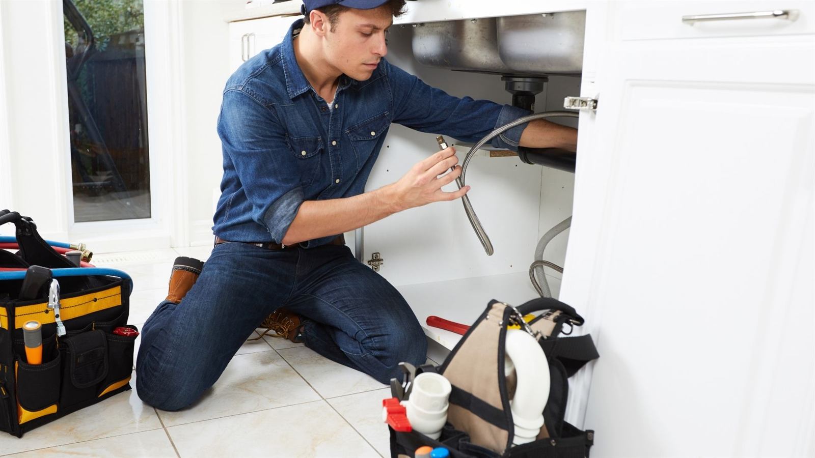 Plumber checking under-sink supply lines in Kernersville, NC