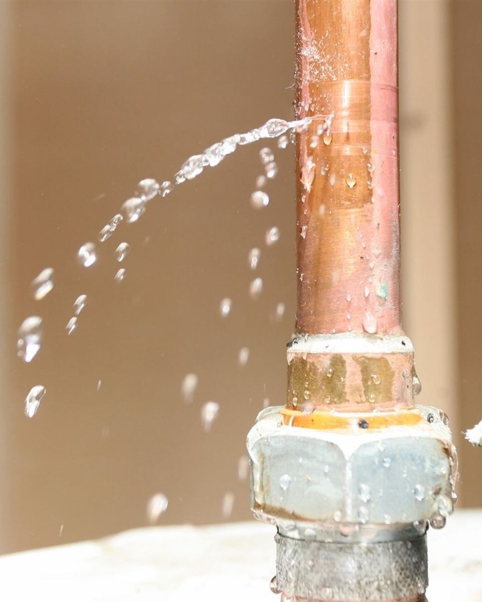 Water spraying from a ruptured supply line beneath an older Rockingham County house