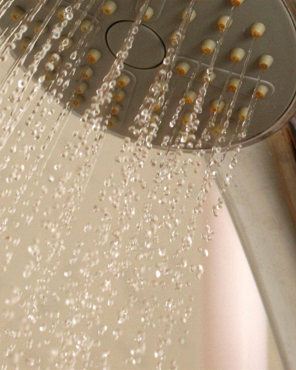 Technician servicing a tankless water heater heat exchanger during an annual descaling